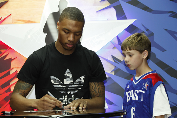 Damian Lillard of the Portland Trail Blazers greets a young fan at the adidas Store at Galleria Mall in Houston during NBA All-Star weekend.
