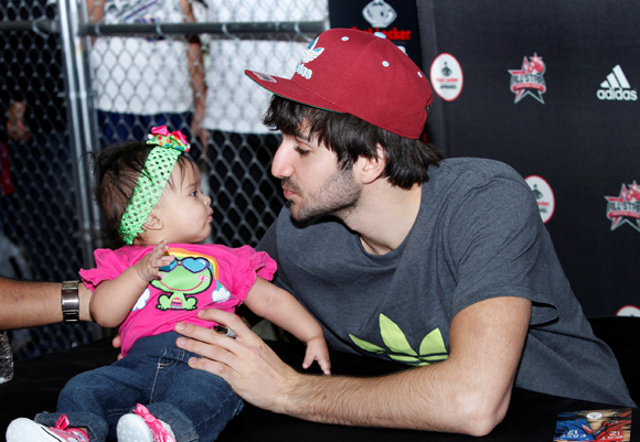 Ricky Rubio of the Minnesota Timberwolves meets a young fan during an appearance at Foot Locker at the Galleria Mall during NBA All-Star.