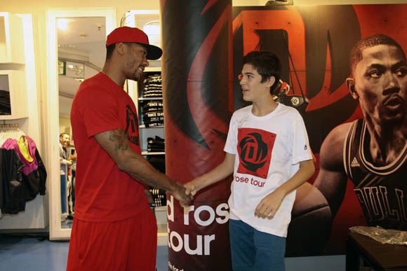  Derrick Rose of the Chicago Bulls surprises a young fan at the adidas Store at El Corte Ingles in Madrid, Spain during the adidas D Rose Tour.