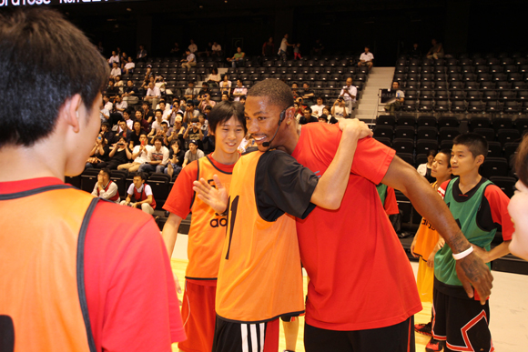 Derrick Rose of the Chicago Bulls hugs a fan at the basketball skills clinic in Sendai, Japan.