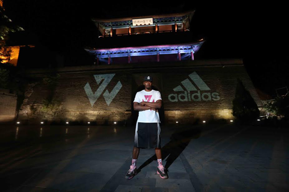 Beijing, China (August 19, 2014) – John Wall poses with his logo projected on the Great Wall of China