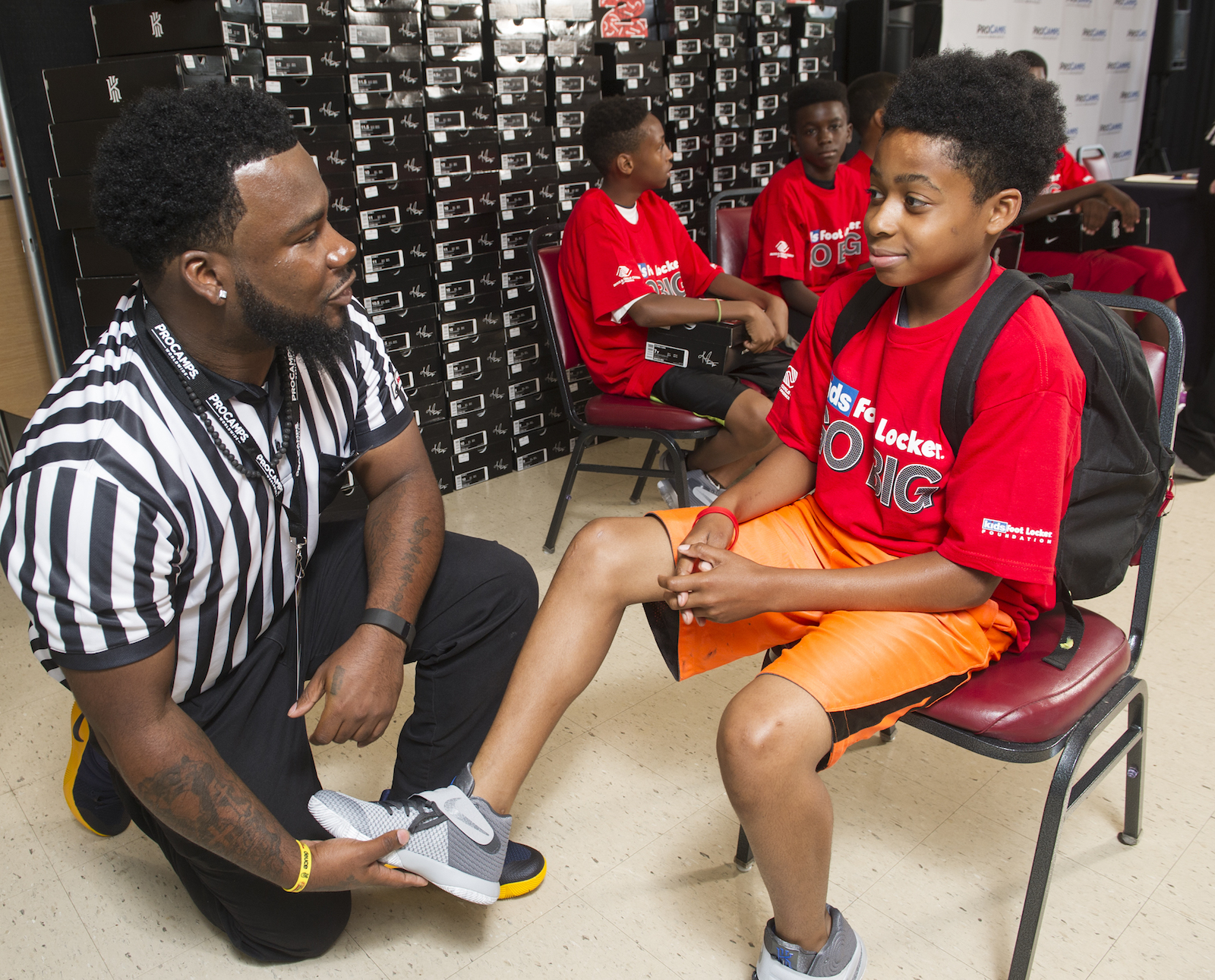 Kids Foot Locker striper Javon Hampton helps Ameer Holman, 11, of Cleveland, fit his Nike Kyrie II signature  shoes, Saturday, July 9, 2016, in Independence, Ohio. Kids Foot Locker donated 190 pairs of sneakers to Boys & Girls Clubs of Cleveland, to match Cleveland Cavaliers star Kyrie Irving's 190 points scored during the NBA championship series.  (Phil Long/AP Images for Kids Foot Locker)