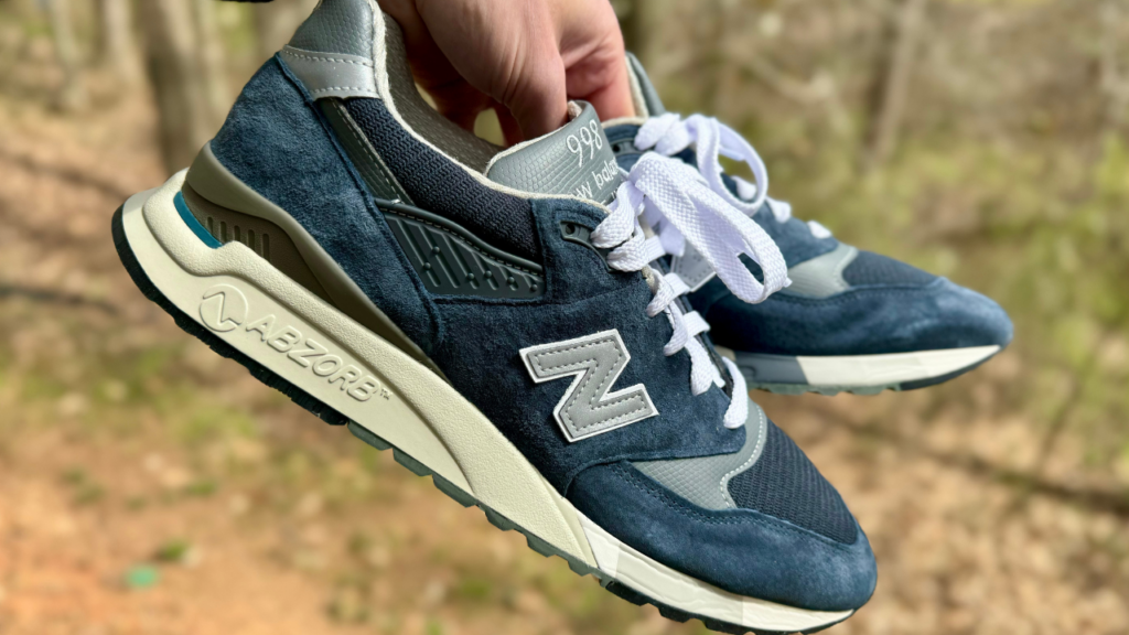 New Balance 998 shoes in hand